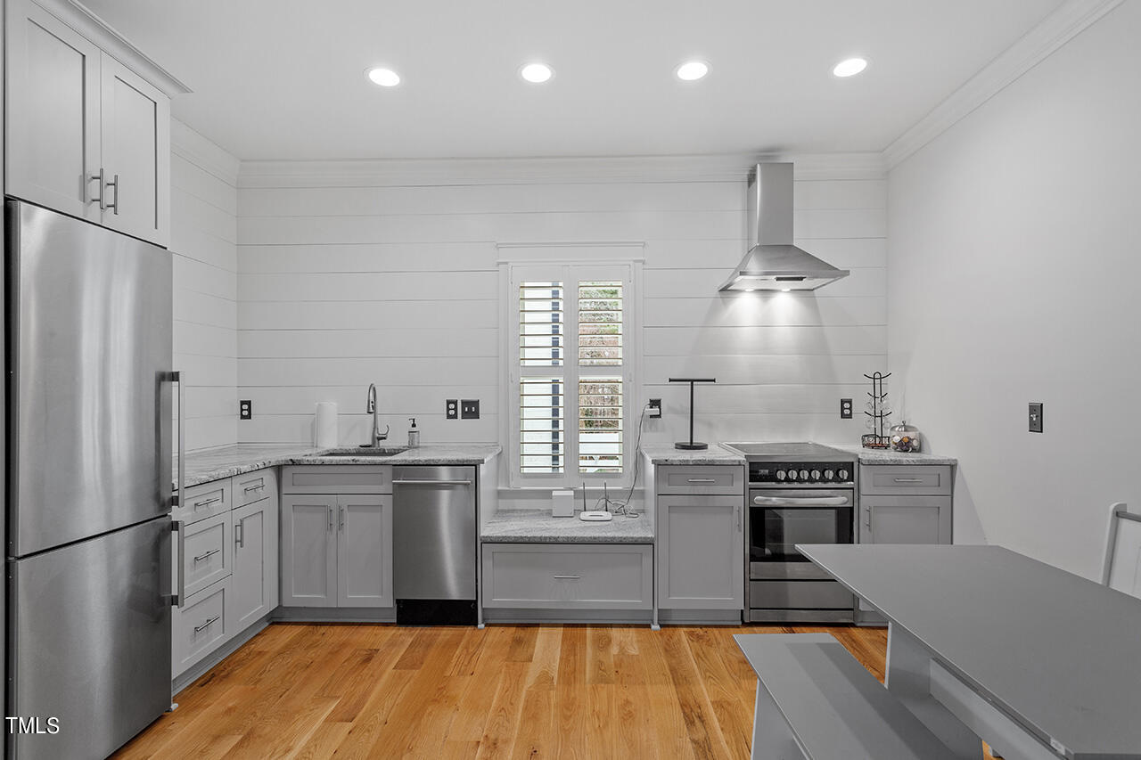 2000 Greyhawk Place Apex, NC 27539 - Photo 55 of 59 a kitchen with stainless steel appliances granite countertop a stove and a refrigerator