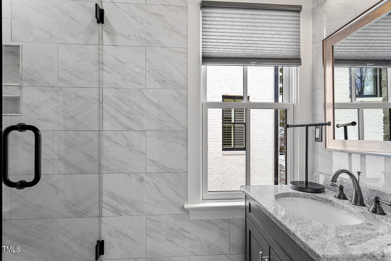 2000 Greyhawk Place Apex, NC 27539 - Photo 58 of 59 a bathroom with a granite countertop sink and a mirror