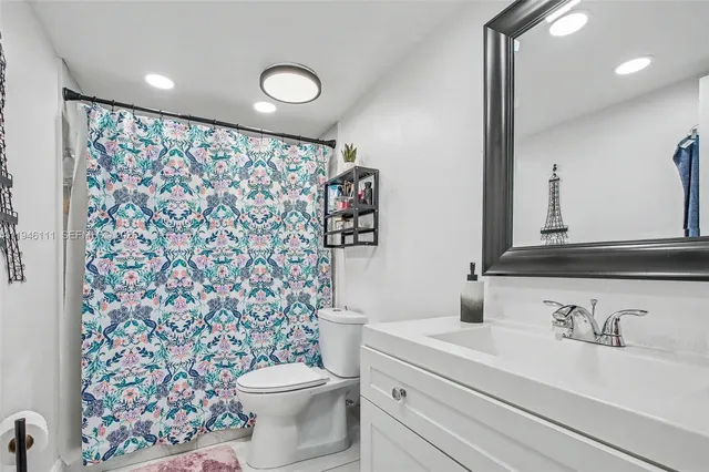 a bathroom with a sink toilet and a mirror