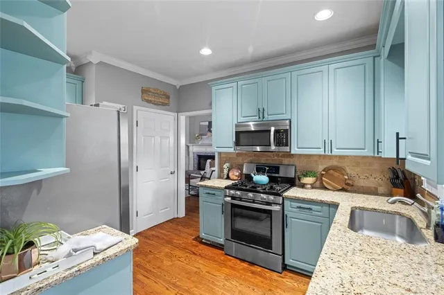 a kitchen with stainless steel appliances granite countertop a sink stove and refrigerator