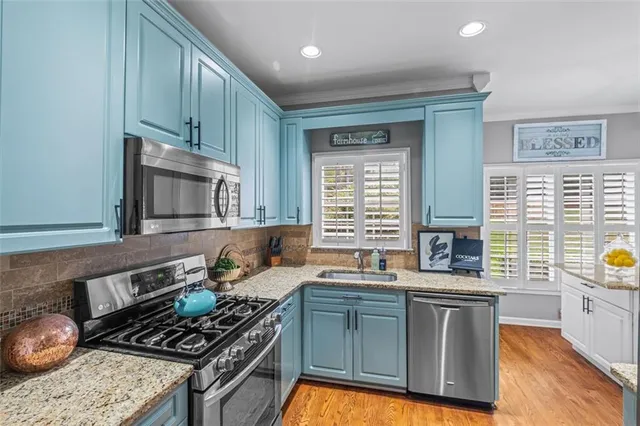 a kitchen with stainless steel appliances granite countertop a stove a sink and a microwave