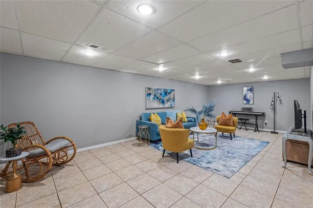a living room with lots of furniture and a potted plant