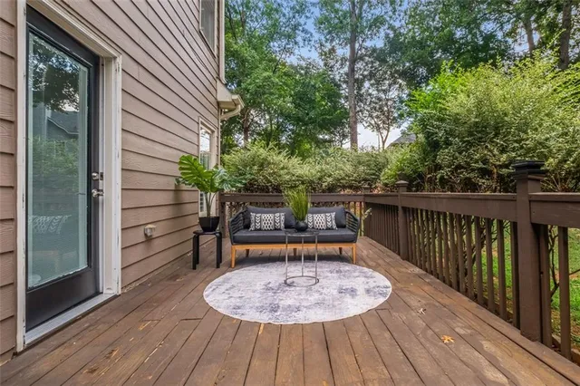 a balcony with wooden floor table and chairs