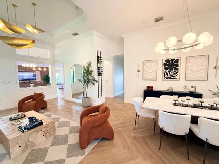 a living room with furniture a chandelier and a flat screen tv