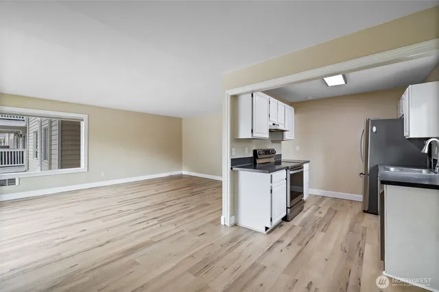 a kitchen with granite countertop a stove top oven a sink dishwasher and a refrigerator with wooden floor