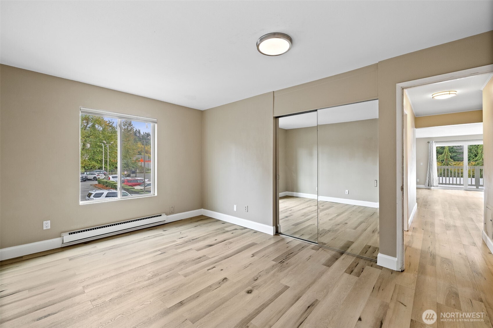 5021 Ripley Lane North, Unit 212 Renton, WA 98056 - Photo 31 of 34 an empty room with wooden floor and windows