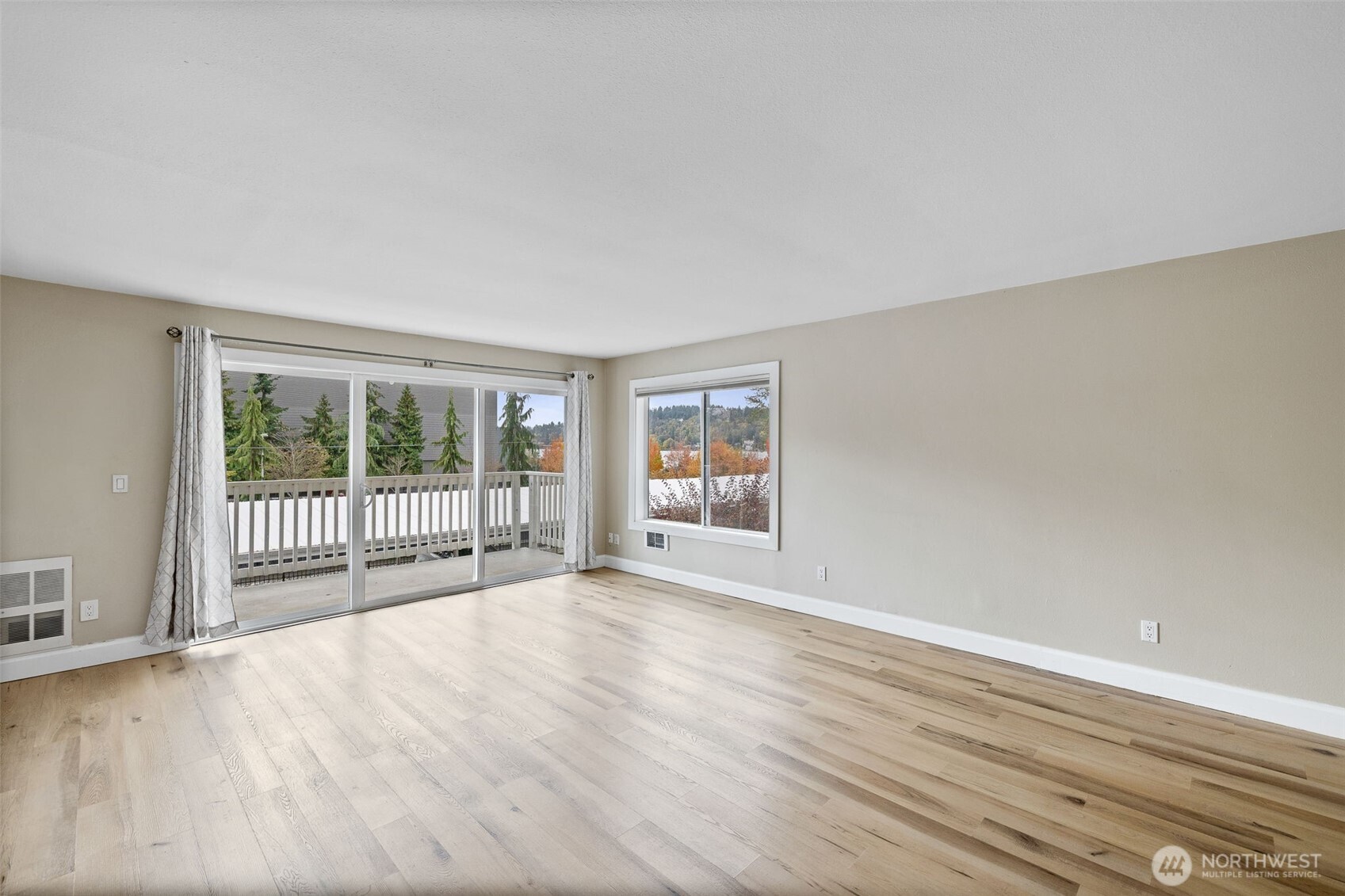 5021 Ripley Lane North, Unit 212 Renton, WA 98056 - Photo 32 of 34 a view of an empty room with wooden floor and a window