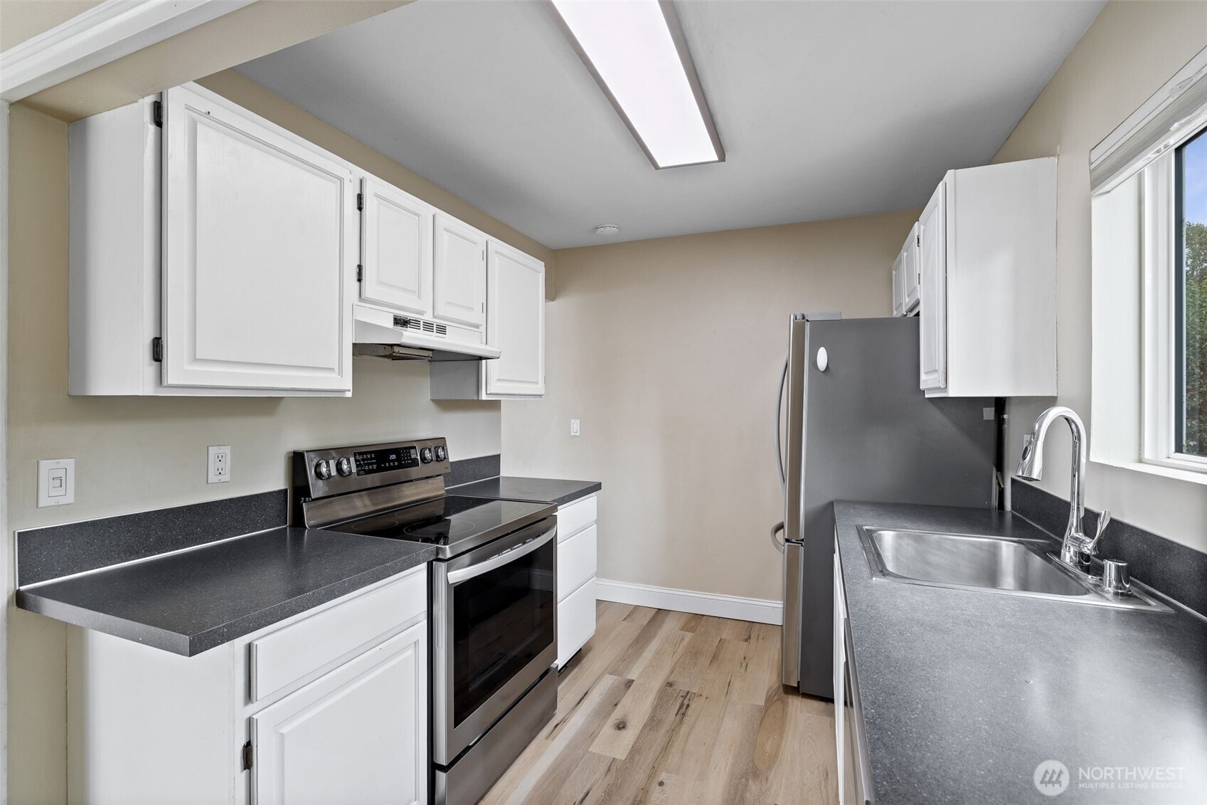 5021 Ripley Lane North, Unit 212 Renton, WA 98056 - Photo 7 of 34 a kitchen with stainless steel appliances granite countertop a sink stove and refrigerator