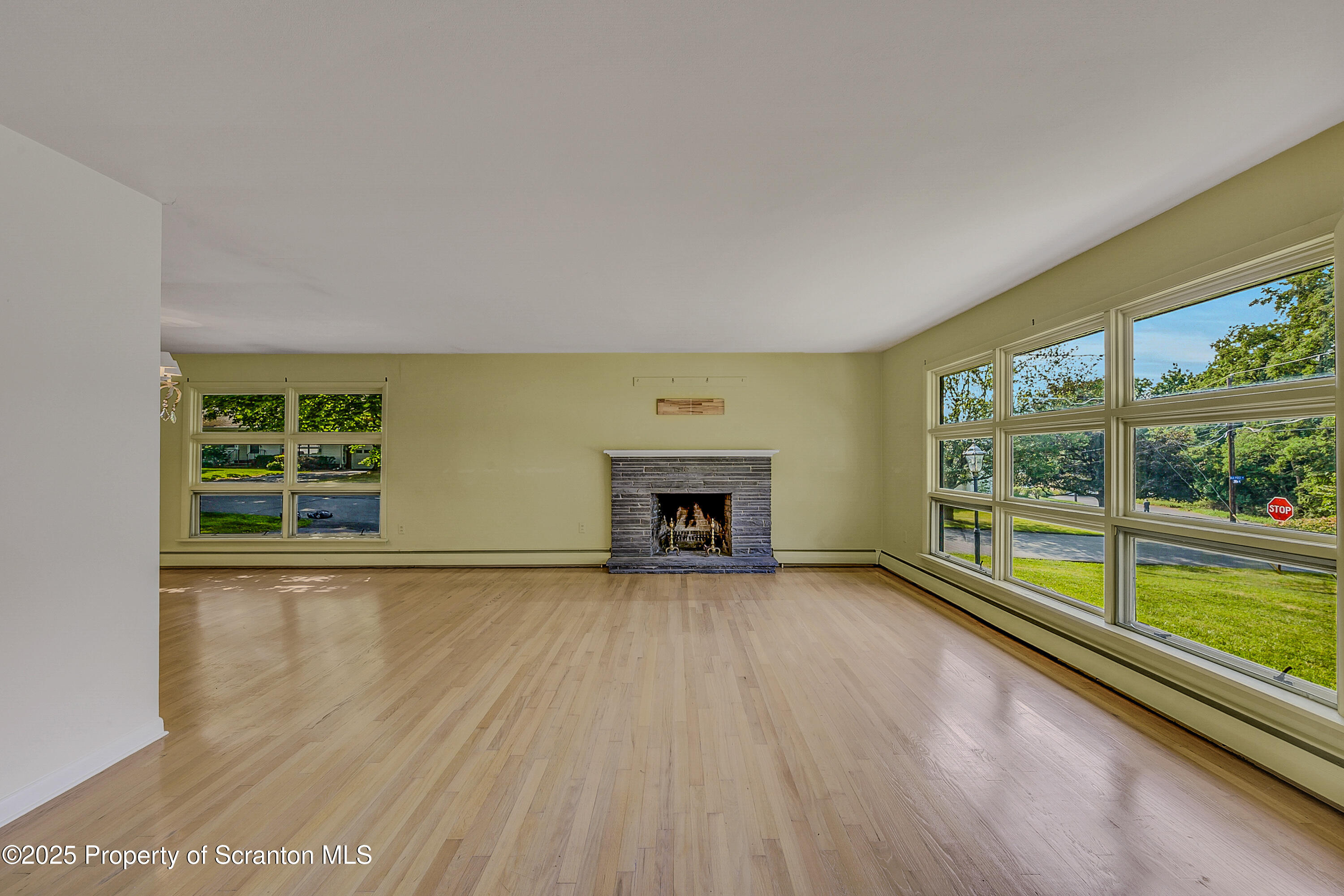 101 Old Post Road Clarks Summit, PA 18411 - Photo 10 of 48 an empty room with wooden floor and a fireplace