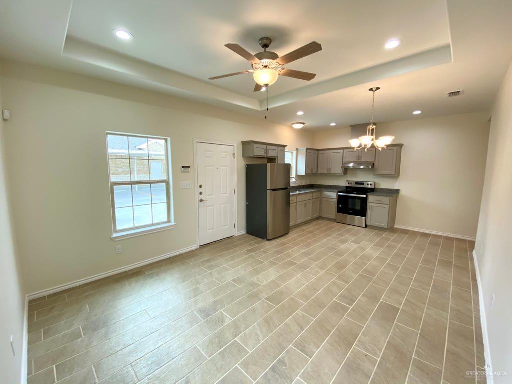 5601 Nightingale Avenue, Unit 2 McAllen, TX 78504 - Photo 4 of 12 Kitchen featuring stainless steel appliances, a tray ceiling, gray cabinetry, a ceiling fan, and under cabinet range hood