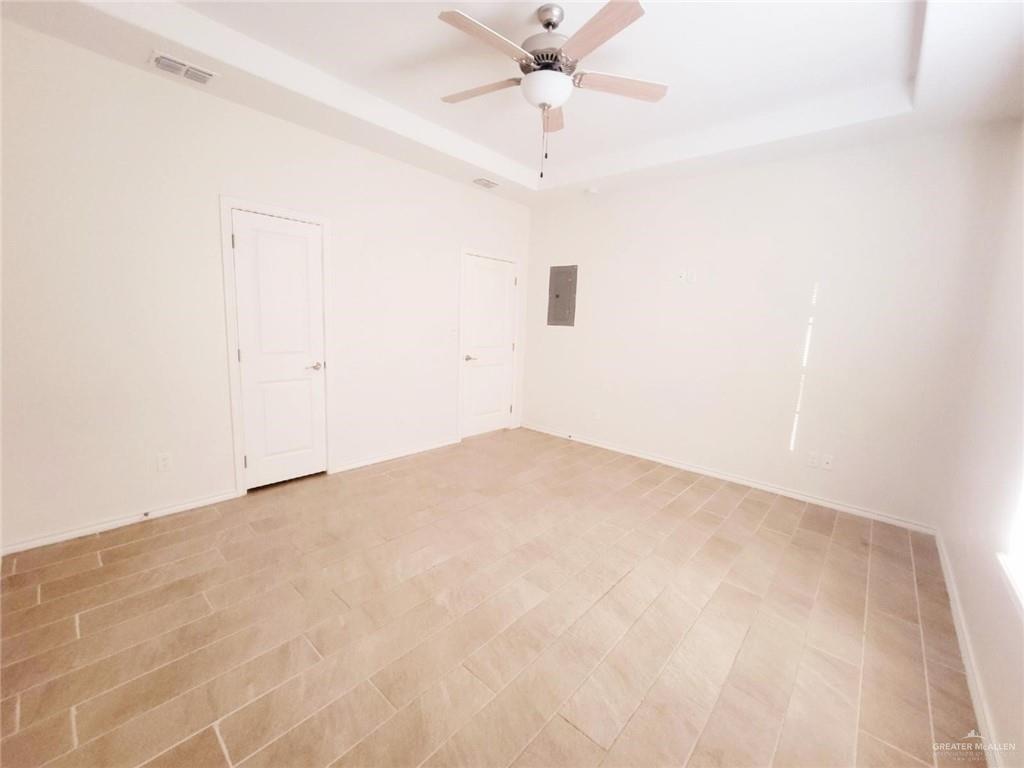 5601 Nightingale Avenue, Unit 2 McAllen, TX 78504 - Photo 7 of 12 Empty room with a raised ceiling, a ceiling fan, and electric panel