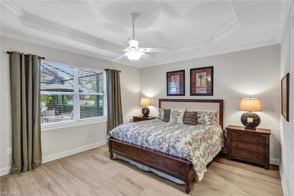 9111 Graphite Circle Naples, FL 34120 - Photo 12 of 33 a bedroom with a large bed chandelier and a window