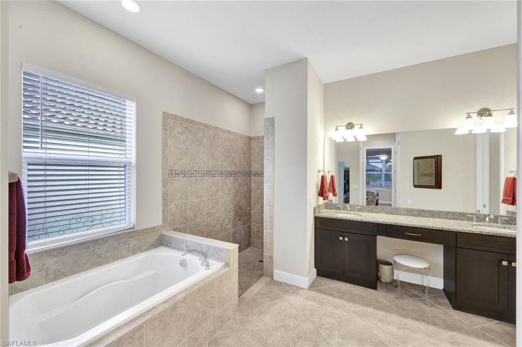 9111 Graphite Circle Naples, FL 34120 - Photo 14 of 33 a spacious bathroom with a tub sink and mirror