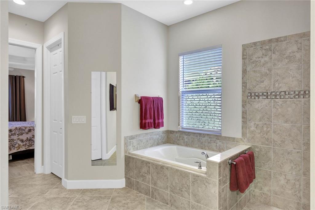 9111 Graphite Circle Naples, FL 34120 - Photo 15 of 33 a bathroom with a tub sink and a shower