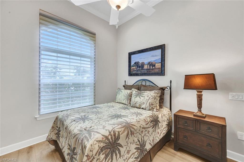 9111 Graphite Circle Naples, FL 34120 - Photo 18 of 33 a bedroom with a bed and a lamp on table