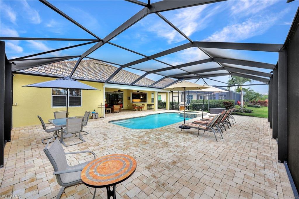 9111 Graphite Circle Naples, FL 34120 - Photo 23 of 33 a view of a swimming pool with a table and chairs in the patio