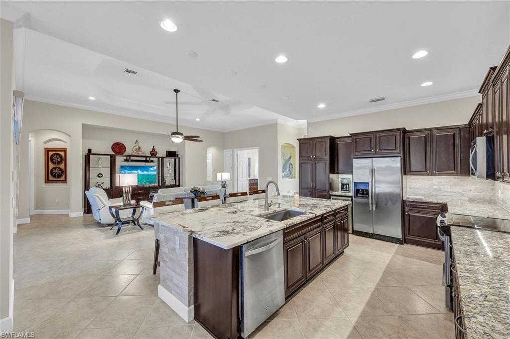 9111 Graphite Circle Naples, FL 34120 - Photo 3 of 33 a kitchen with stainless steel appliances granite countertop a sink and a refrigerator