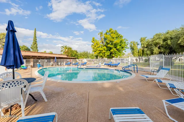 a view of a swimming pool with a patio and a yard