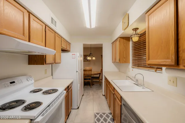 a kitchen with a sink stove top oven and cabinets