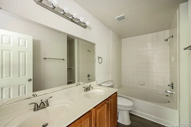 a bathroom with a sink double vanity granite toilet tub and shower