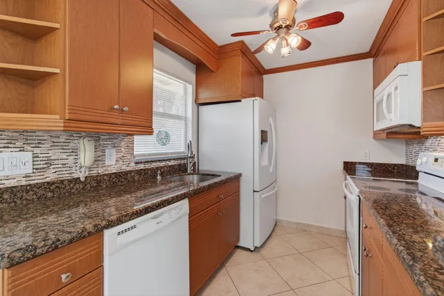 a kitchen with granite countertop a sink and a refrigerator