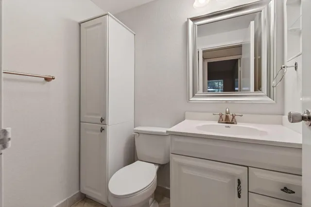 a bathroom with a toilet sink vanity and mirror