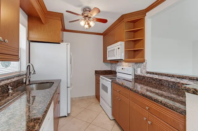 a kitchen with stainless steel appliances granite countertop a sink and a stove