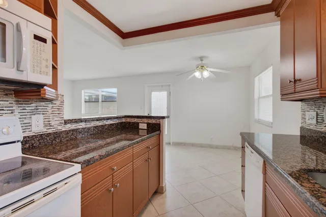 a kitchen with granite countertop a sink and a stove