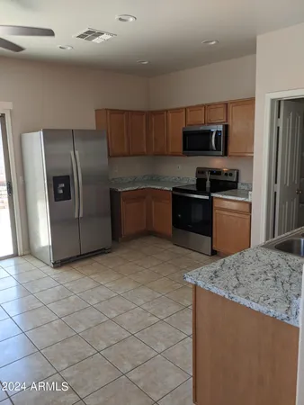 a kitchen with stainless steel appliances granite countertop a stove a sink and a refrigerator