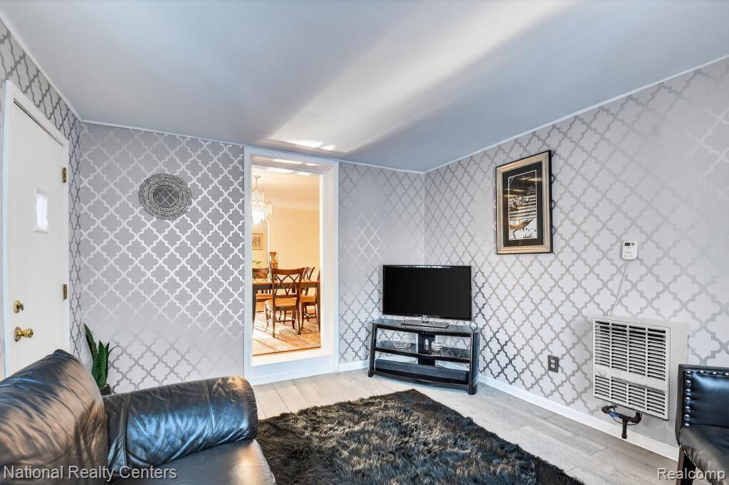 3956 Harvard Road Detroit, MI 48224 - Photo 19 of 44 Patterned wallcovering, wood-finish flooring, recessed lighting, wall-mounted heating unit, and an open doorway to another room