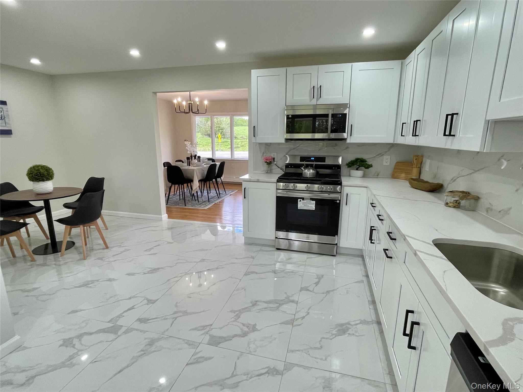 70 County Rte 17 Pine Bush, NY 12566 - Photo 11 of 36 a kitchen with stainless steel appliances granite countertop a stove top oven a sink dishwasher and white cabinets with wooden floor