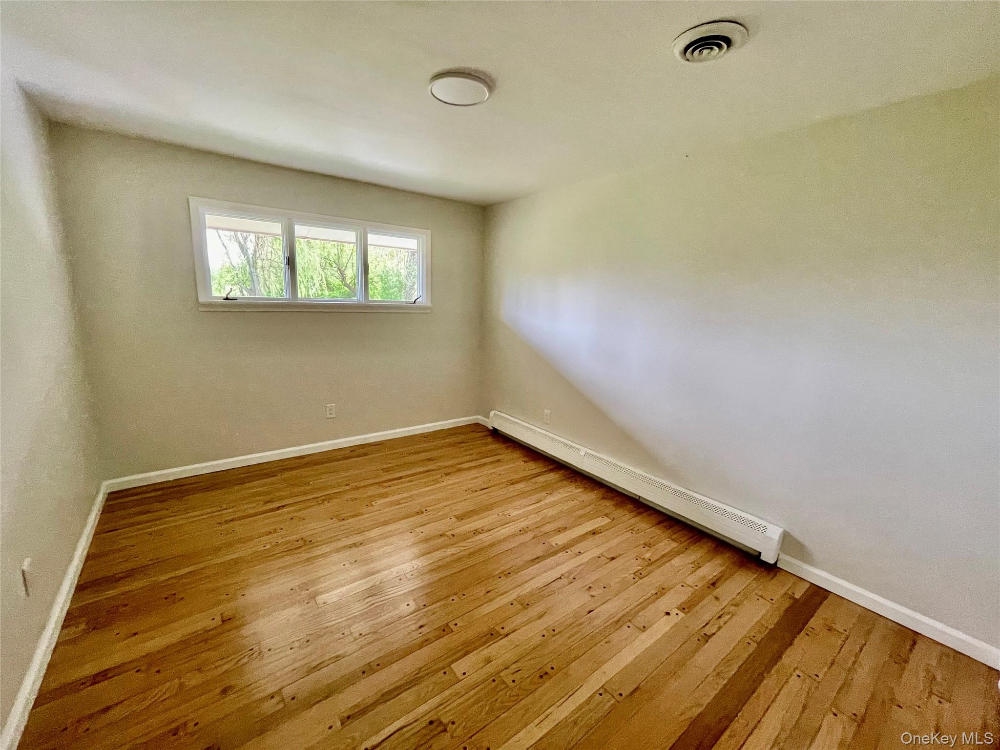 70 County Rte 17 Pine Bush, NY 12566 - Photo 23 of 36 a view of an empty room with wooden floor and a window