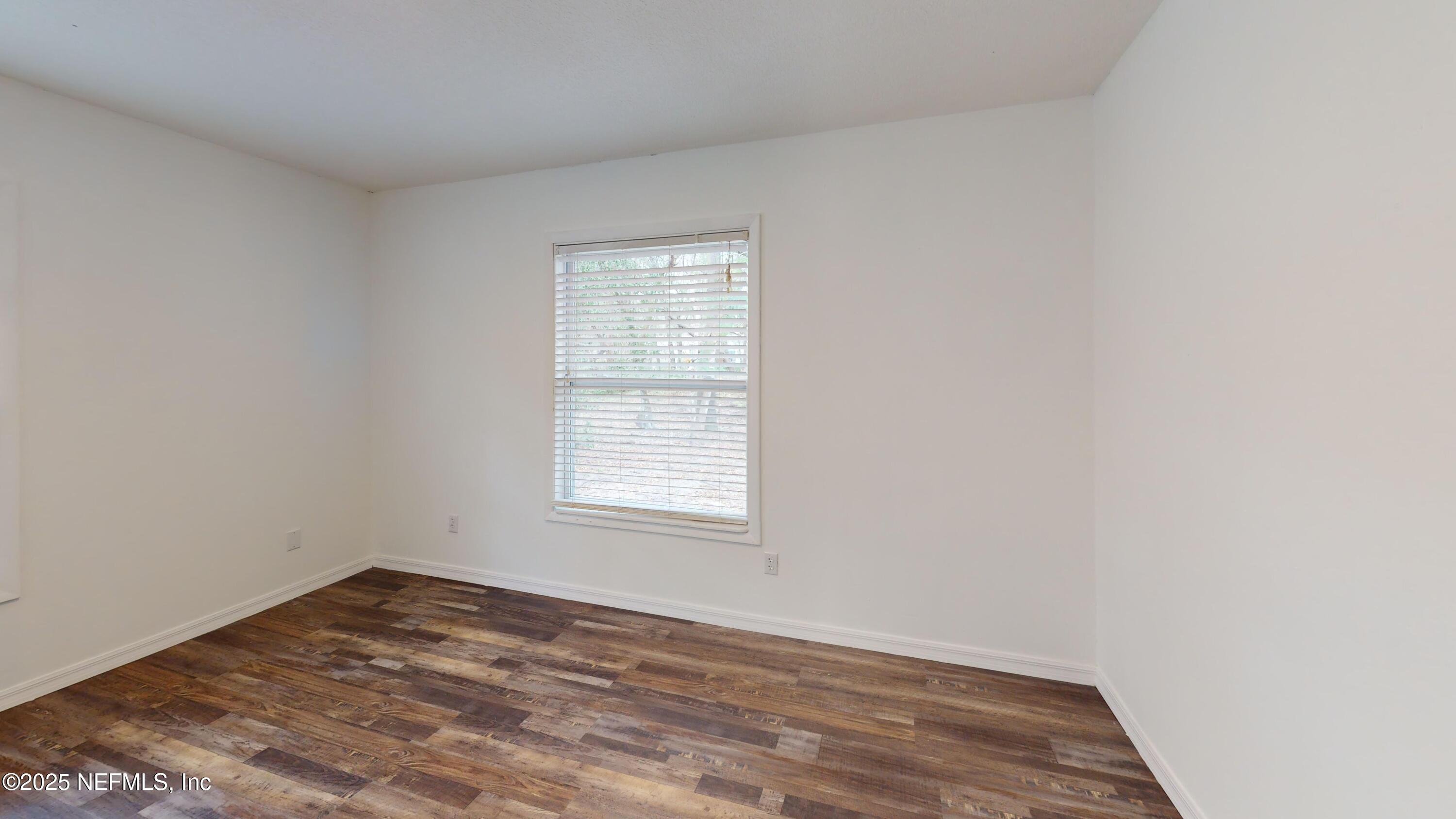201 Florence Avenue Interlachen, FL 32148 - Photo 5 of 17 an empty room with wooden floor and window