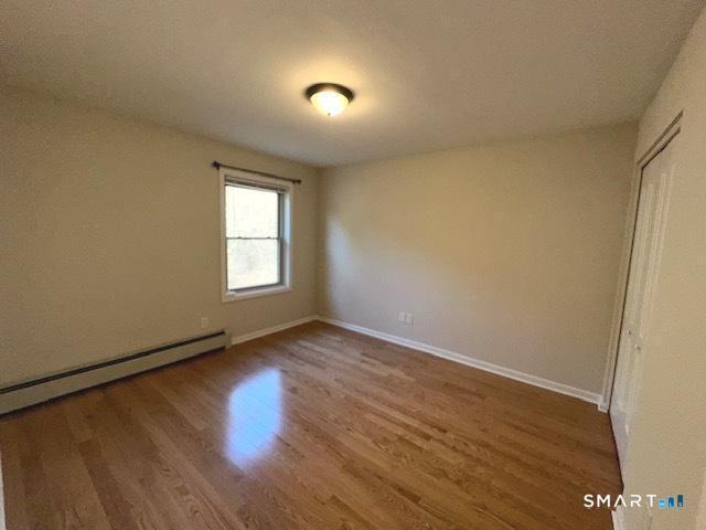 97 Country Hill Road, Unit 97 Naugatuck, CT 06770 - Photo 14 of 31 an empty room with wooden floor and windows