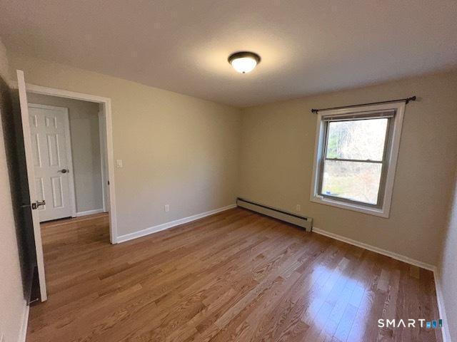 97 Country Hill Road, Unit 97 Naugatuck, CT 06770 - Photo 15 of 31 an empty room with wooden floor and windows
