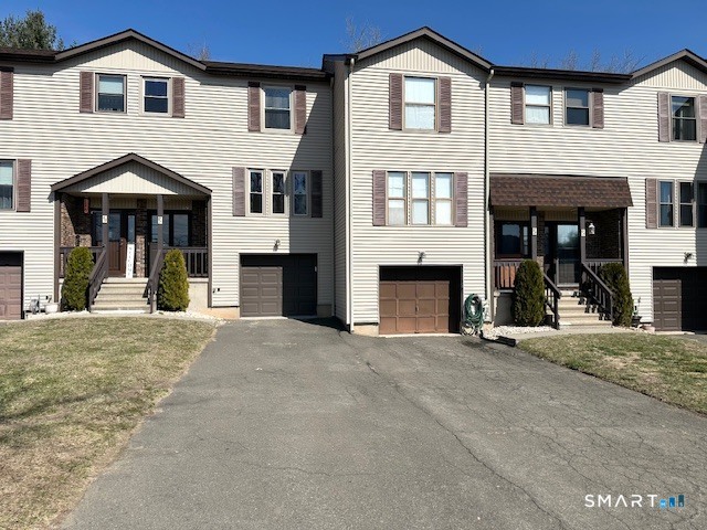 97 Country Hill Road, Unit 97 Naugatuck, CT 06770 - Photo 28 of 31 a front view of a house with a yard and garage