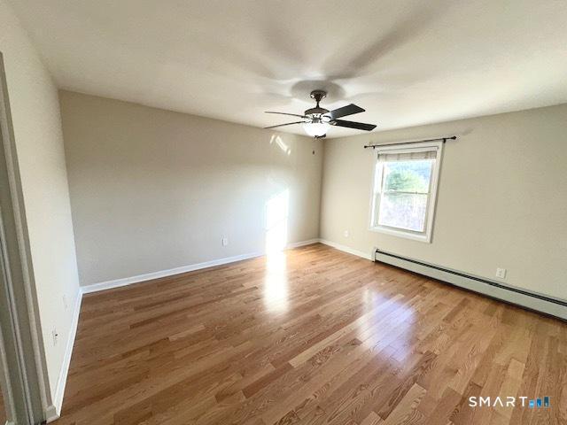 97 Country Hill Road, Unit 97 Naugatuck, CT 06770 - Photo 8 of 31 an empty room with wooden floor and windows