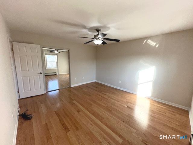 97 Country Hill Road, Unit 97 Naugatuck, CT 06770 - Photo 9 of 31 wooden floor in an empty room with a window