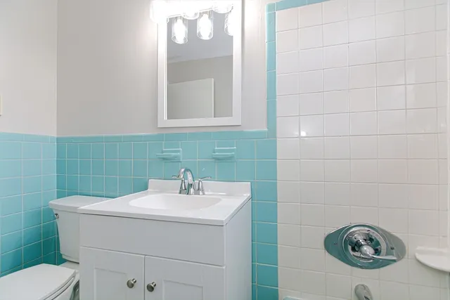 a bathroom with a sink toilet and mirror
