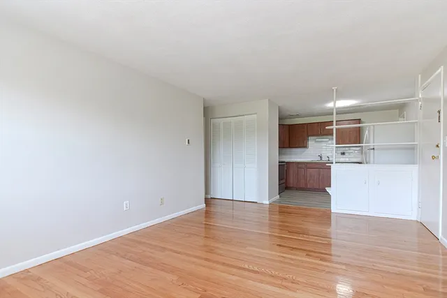 a view of empty room with wooden floor