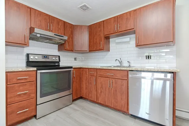 a kitchen with granite countertop cabinets stainless steel appliances and a sink