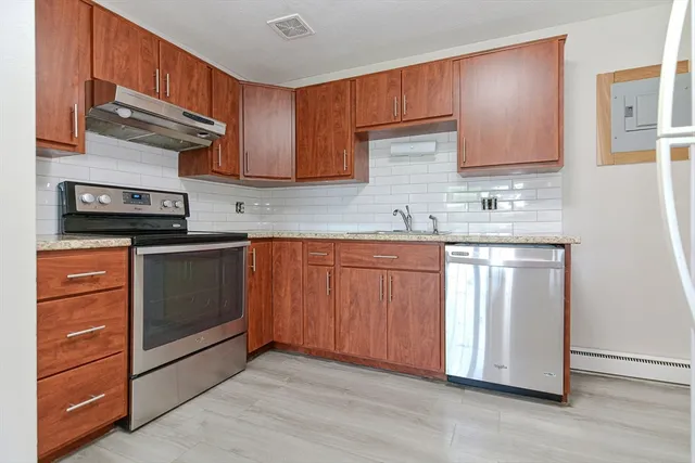 a kitchen with stainless steel appliances granite countertop a stove a sink and a microwave