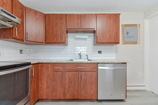 a kitchen with stainless steel appliances granite countertop wooden cabinets a sink and dishwasher