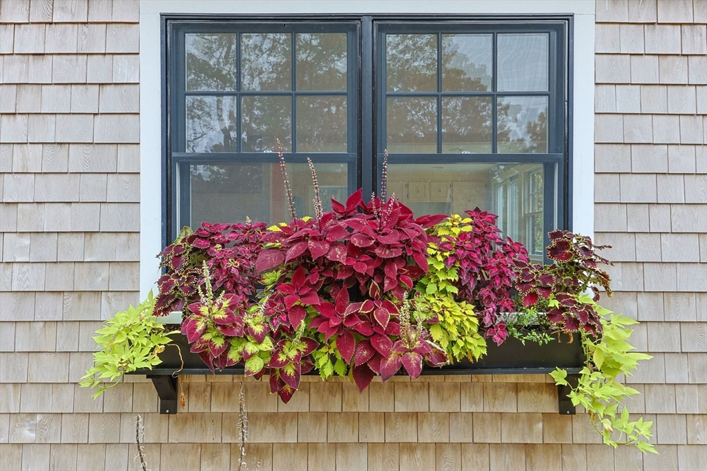 30 Mayflower Road Eastham, MA 02642 - Photo 2 of 38 a flower pot with a wooden bench