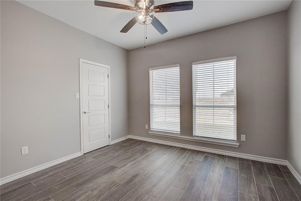 106 Peridot Street Portland, TX 78374 - Photo 13 of 17 an empty room with wooden floor chandelier fan and windows