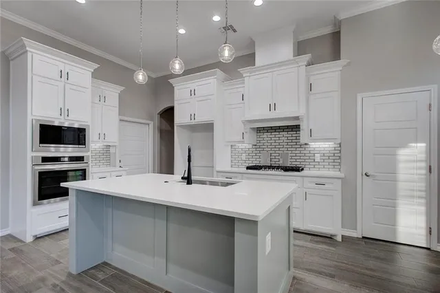 a kitchen with white cabinets and stainless steel appliances