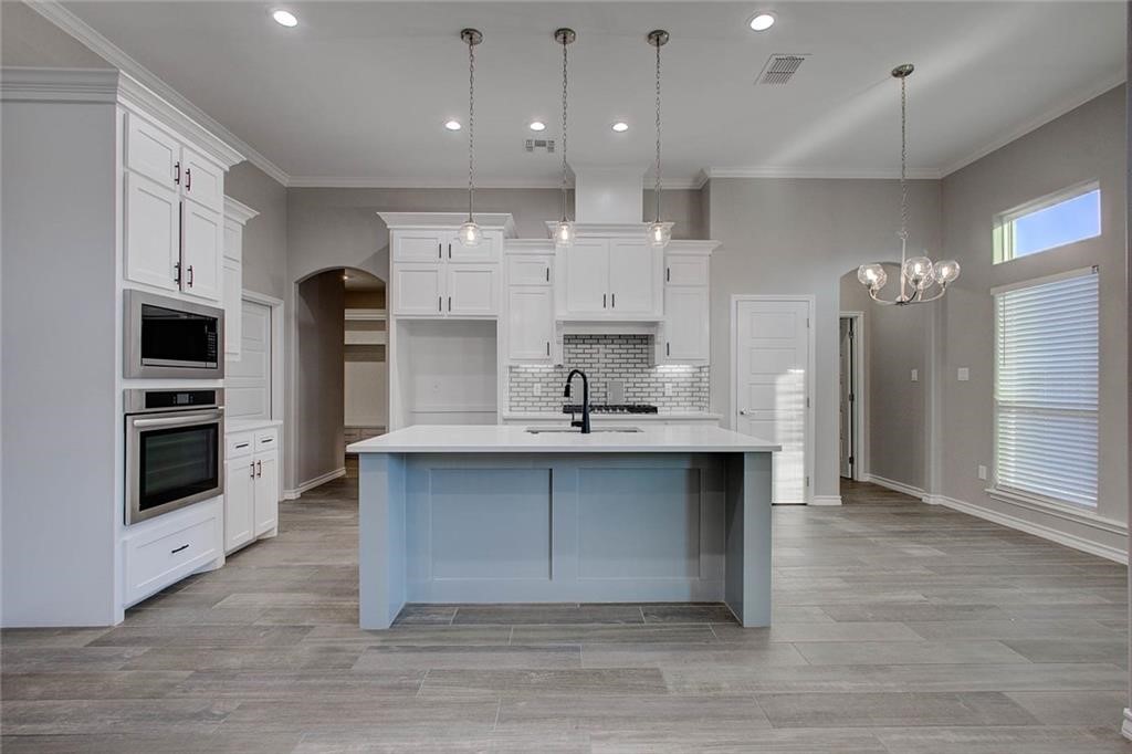 106 Peridot Street Portland, TX 78374 - Photo 5 of 17 a large kitchen with stainless steel appliances a large counter top a sink and a refrigerator