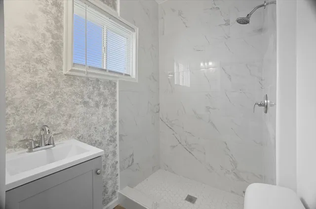 a bathroom with a sink toilet and shower