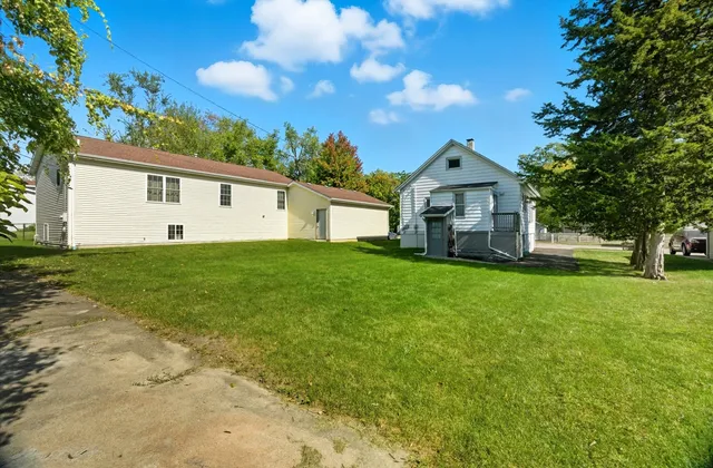a front view of a house with a yard and trees