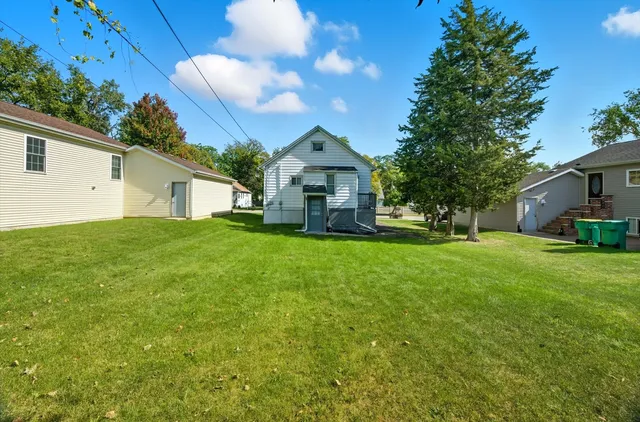 a front view of a house with a garden and trees